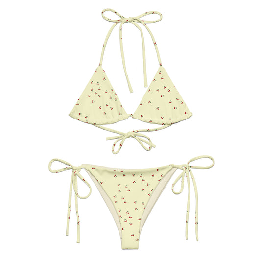 A yellow bikini set called the Cherry Orchard Bikini Set, made from high-quality, soft, and stretchy material with UPF 50+ sun protection. This eco-friendly bikini set is perfect for swimming, sunbathing, or poolside lounging. It comes in a wide range of